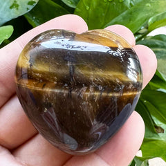 Favoramulet polished heart stone Tiger's Eye in palm use, promoting calm moments and focus