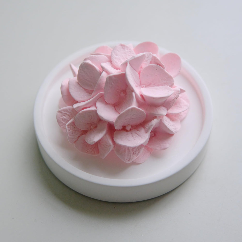 Elegant pink hydrangea FLCSIed diffuser adds refined ambiance to workspace.