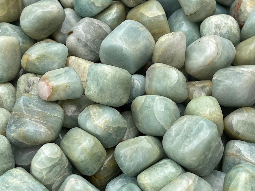 GAF Treasures Aquamarine tumbled stones shown in hand for meditation