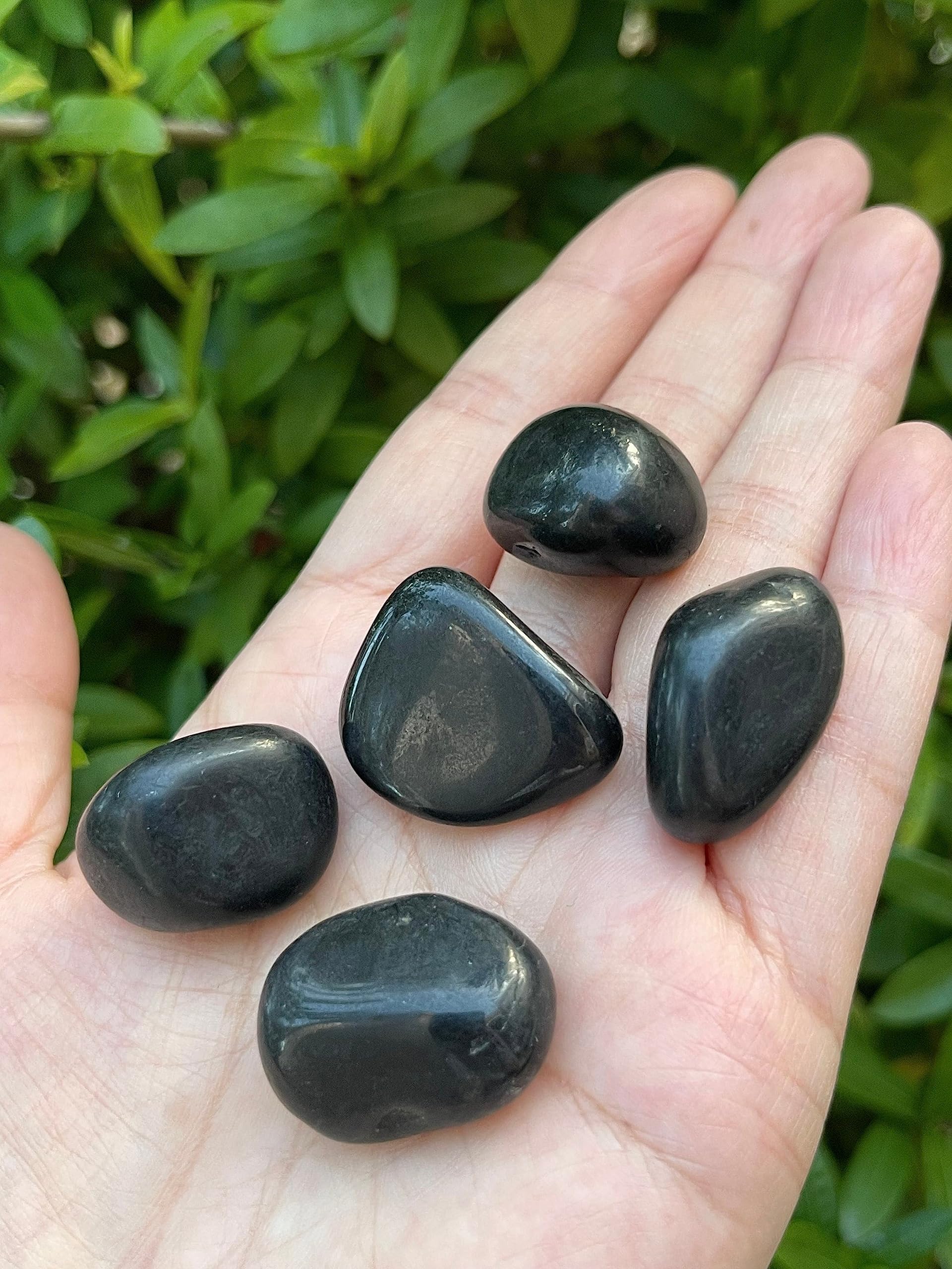 GAF TREASURES polished stones next to candle for ritual energy clearing.
