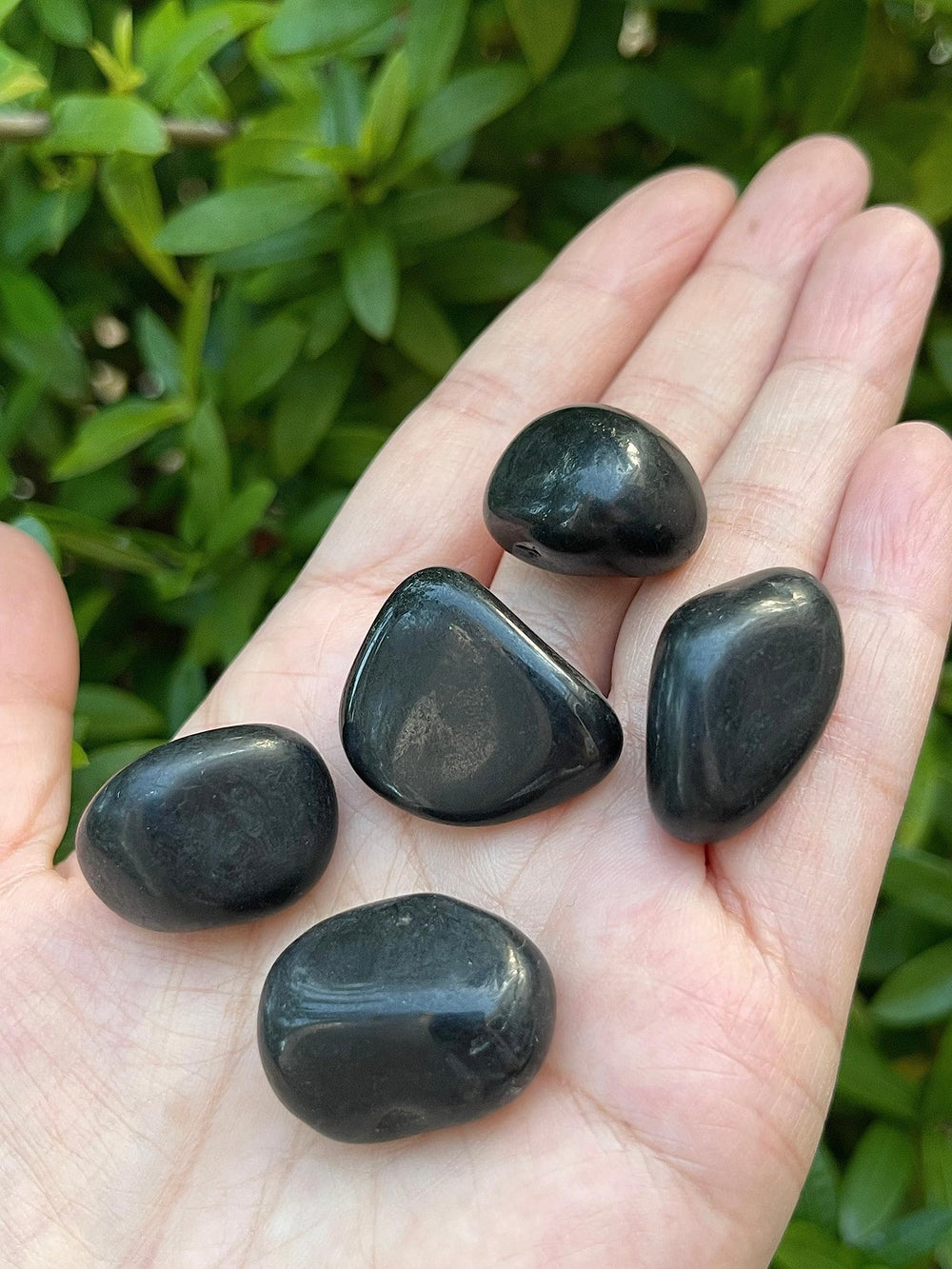 GAF TREASURES polished stones next to candle for ritual energy clearing.