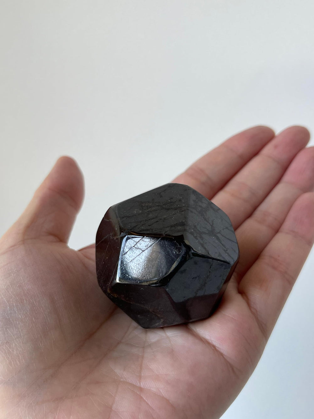 GAF TREASURES garnet polygon polished in hand highlighting size and heft