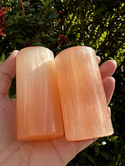 Close-up of orange selenite harmonizer cylinder showing hand-polished finish and natural texture.