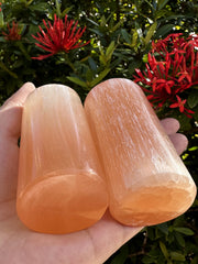Side view of orange selenite cylinder in living space for focused energy and calm ambiance.
