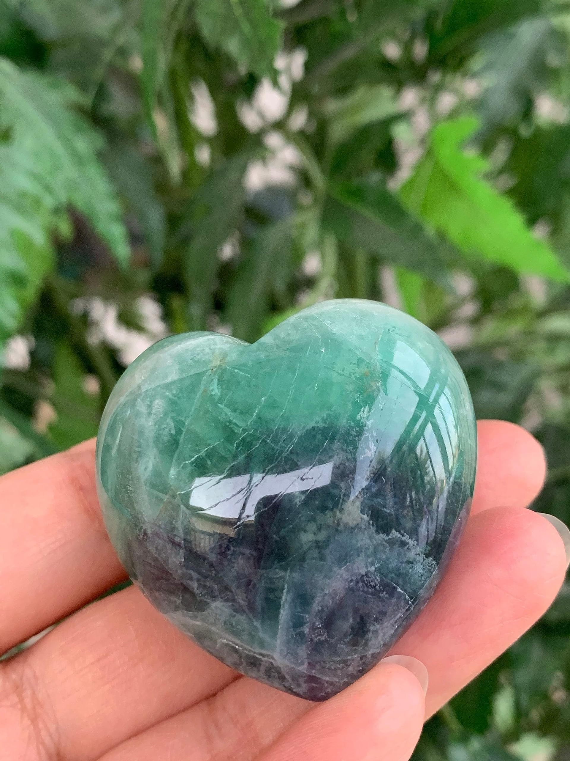 GAF TREASURES Rainbow Fluorite Heart palm stone resting in hand promotes relaxation