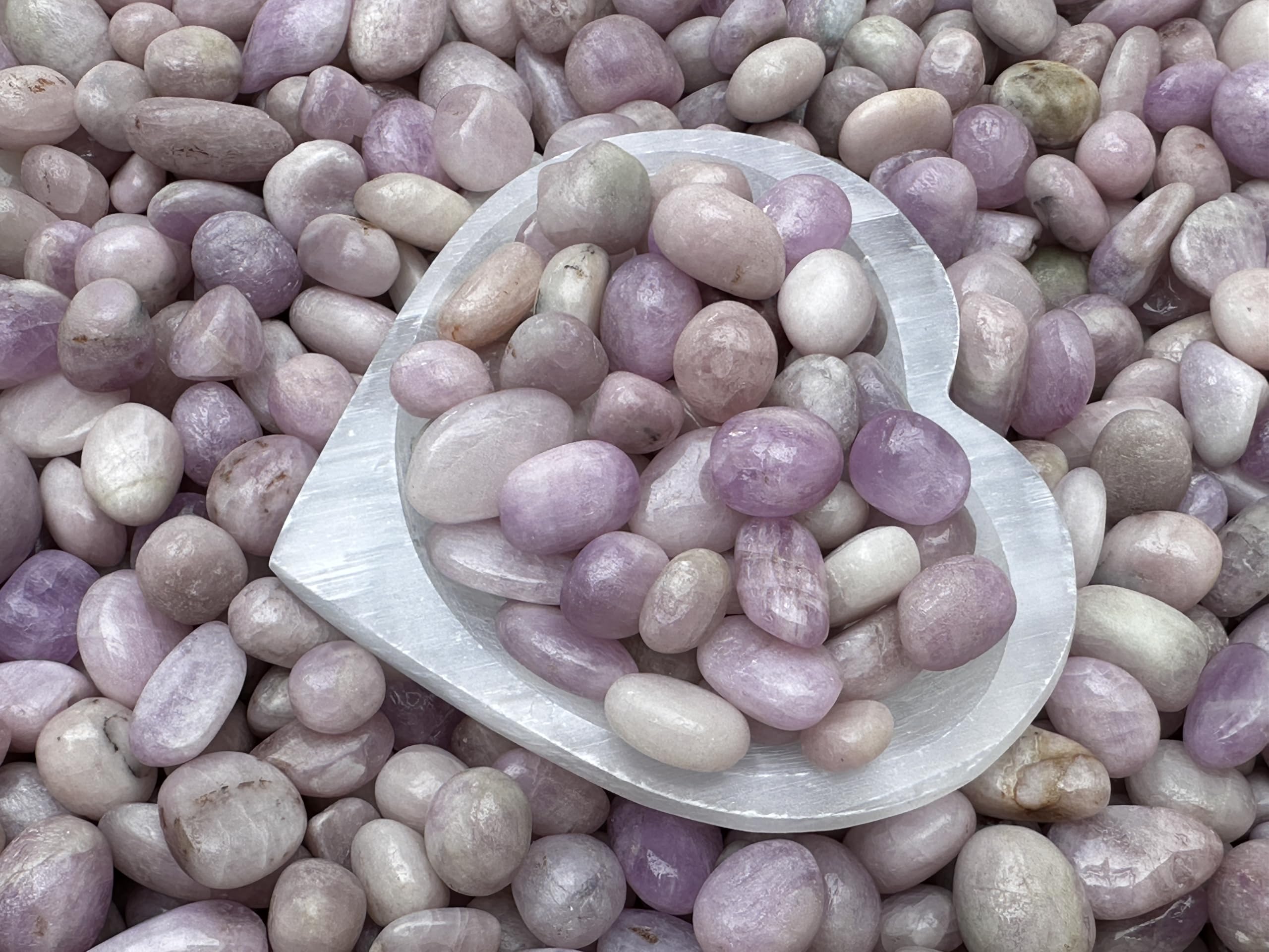 GAF TREASURES Kunzite polished stone close-up showing smooth finish and color variation.