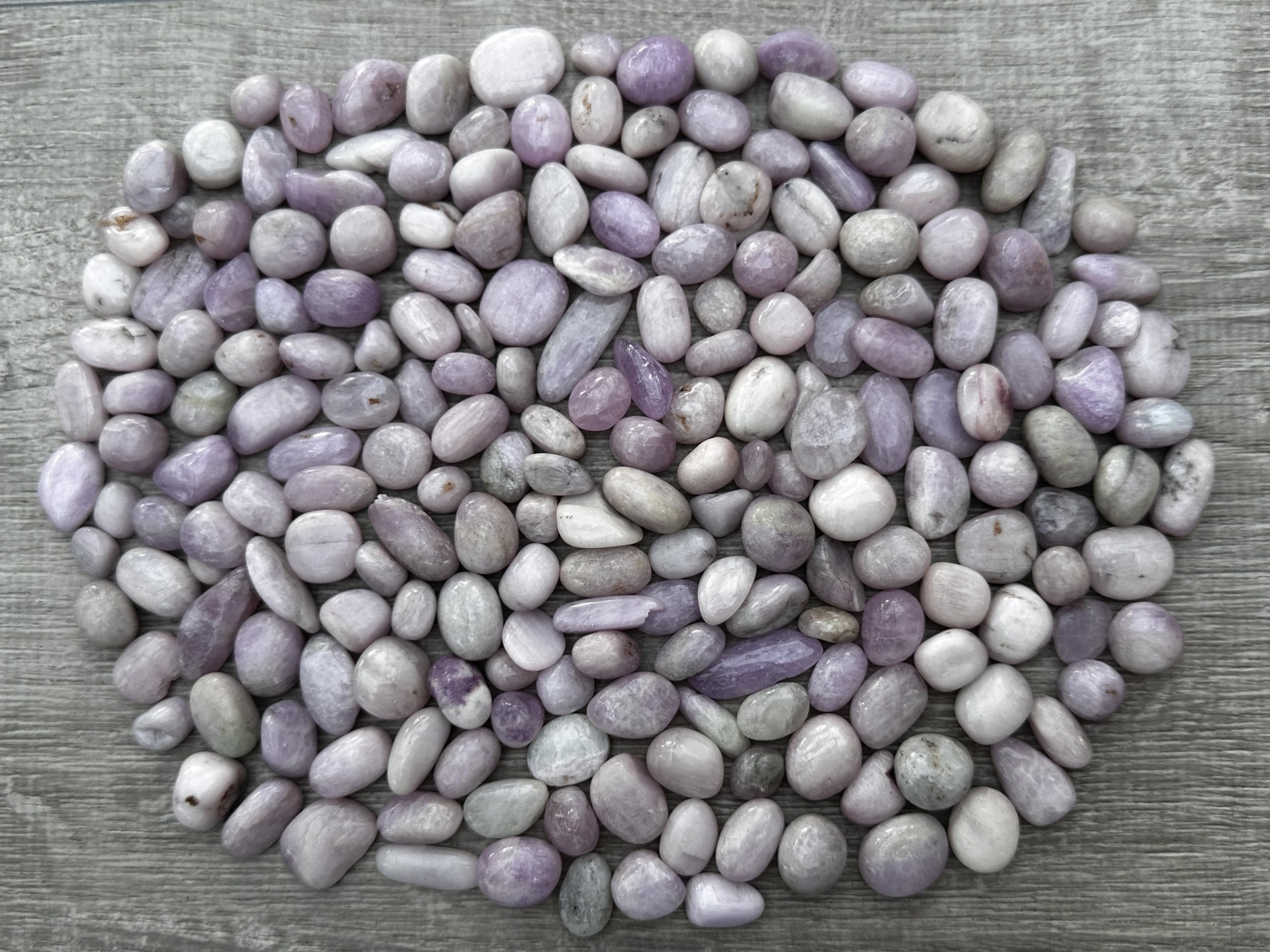 GAF TREASURES Kunzite tumbled stones in soft pink hues for calming meditation.