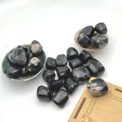 Close-up of GEMSCITE Black Tourmaline tumbles showing natural texture and polish.