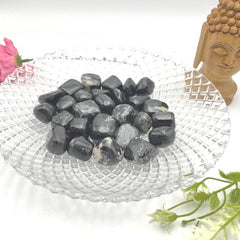 GEMSCITE Black Tourmaline tumbles arranged in a decorative bowl for serenity.