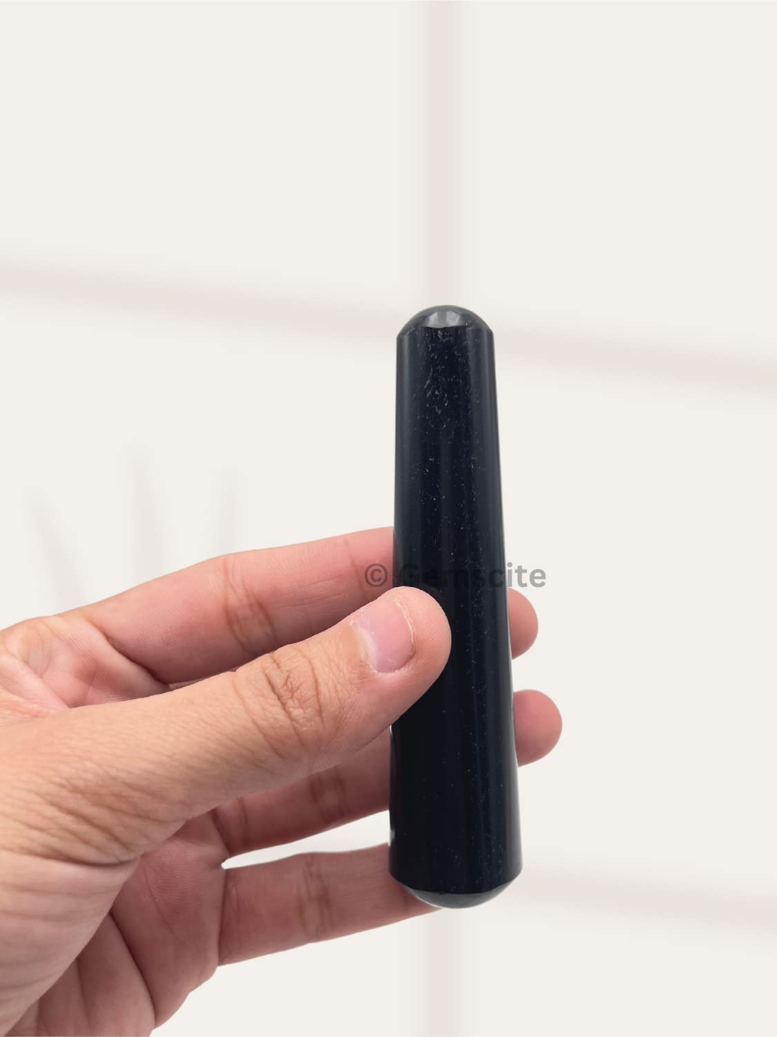 Natural stone texture on gemstone wand enhances grounding practice.