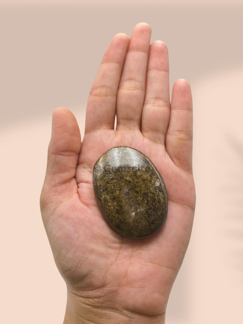 GEMSCITE Bronzite palm stone shown on desk for daily intention reminders.
