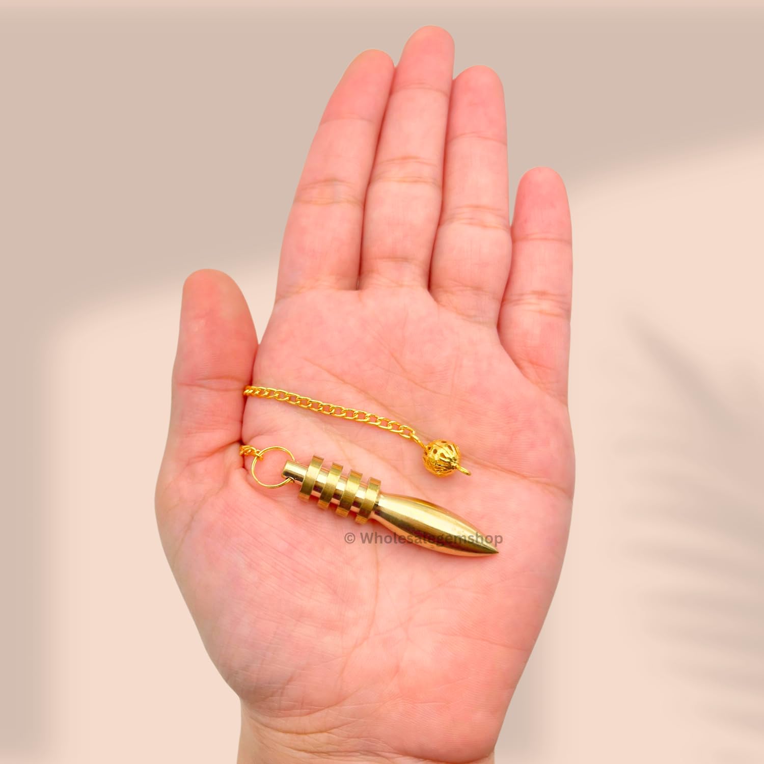 GEMSCITE pendulum in dowsing practice for focused energy readings.