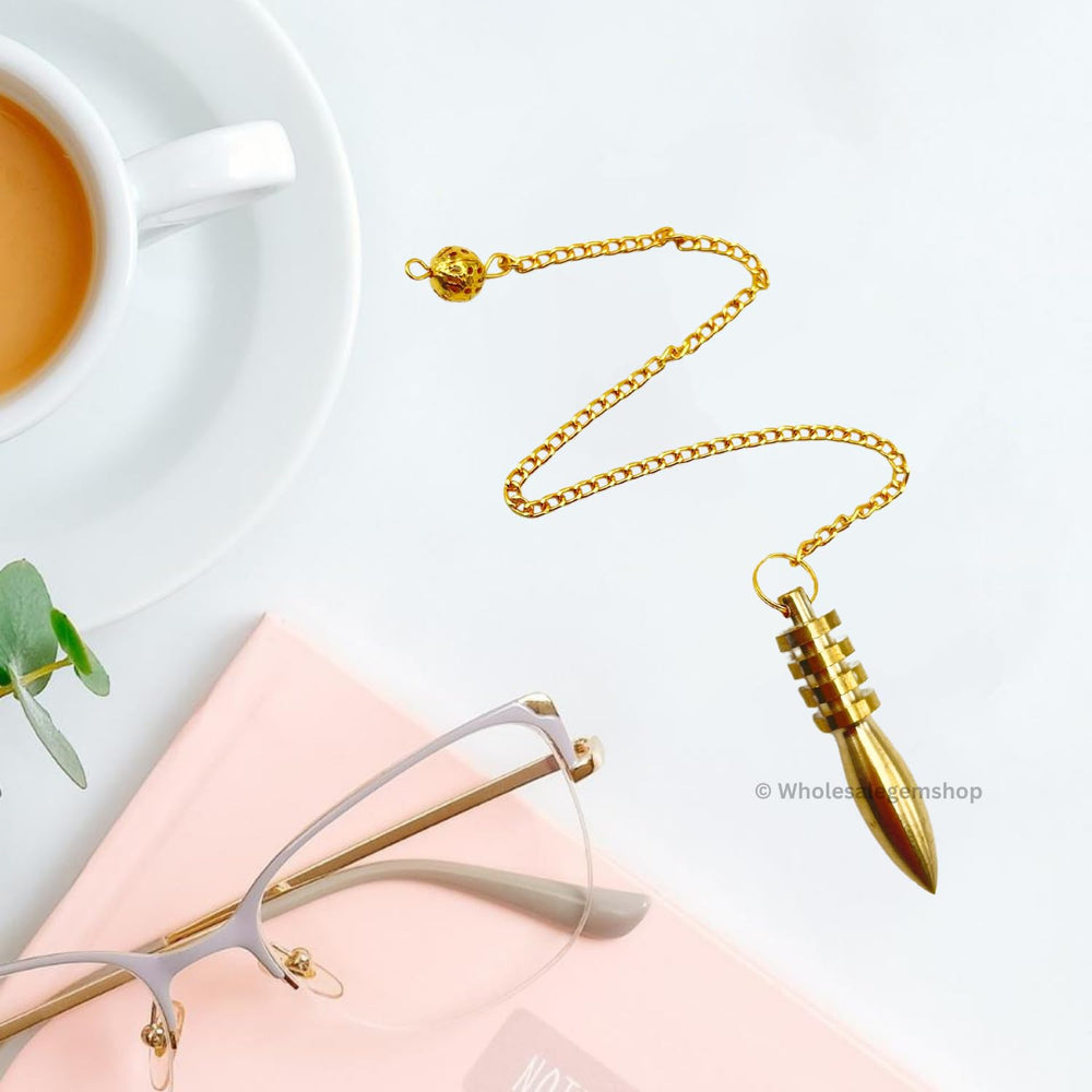 GEMSCITE pendulum shown in light, highlighting the gold-plated finish.