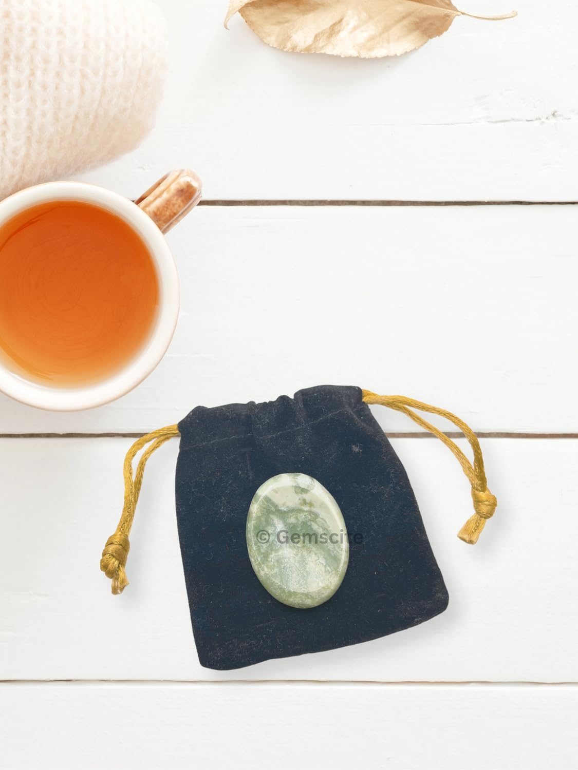 GEMSCITE Serpentine worry stone shown in use during a quiet moment.
