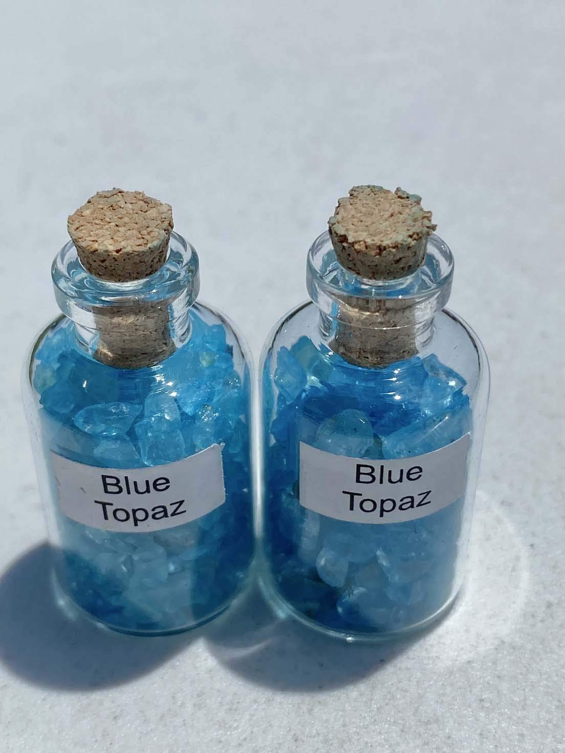Generic Blue Topaz Crystal Mini Bottle shown among crystals for display.
