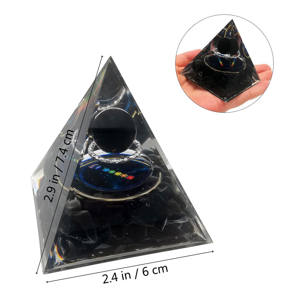 Gosyfeti Orgone Pyramid shows planet and silver circle design, catching sunlight.