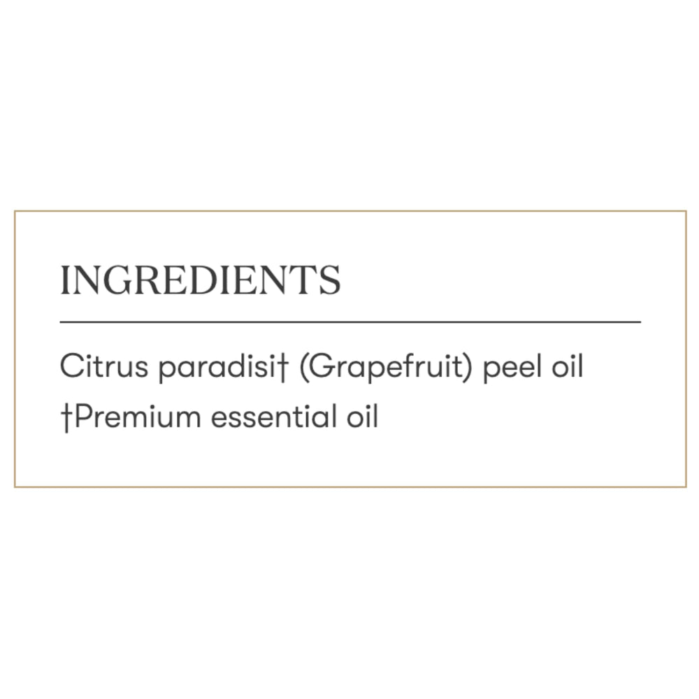 Grapefruit essential oil bottle beside a diffuser releasing refreshing scent