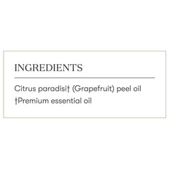 Grapefruit essential oil bottle beside a diffuser releasing refreshing scent