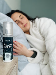 Close up of Habits lavender mist pouring toward pillows to refresh the sleep surface