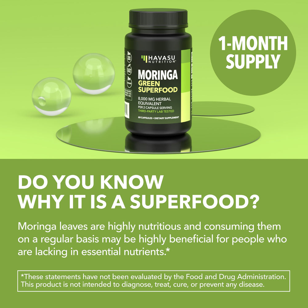 Green superfood capsules sit beside a glass of water.