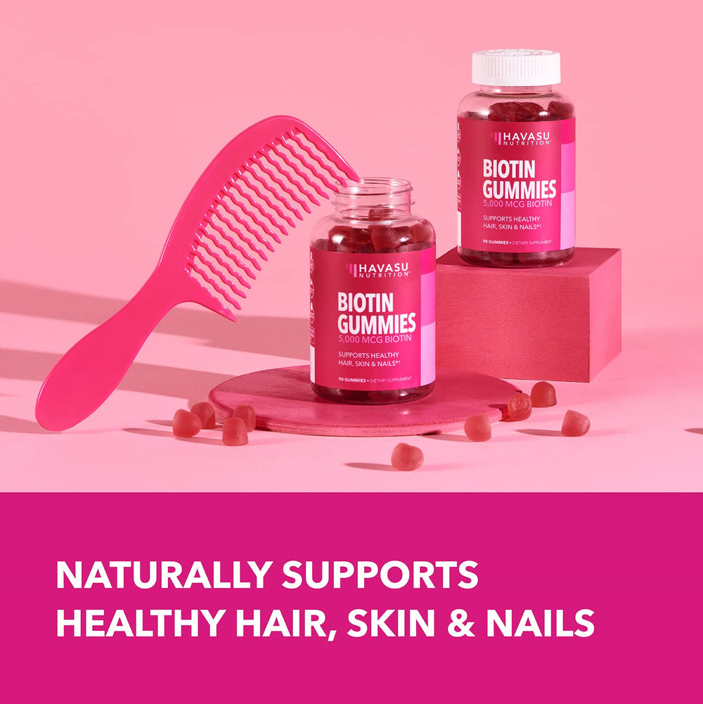 Strawberry HAVASU Biotin gummies beside water for daily beauty routine.