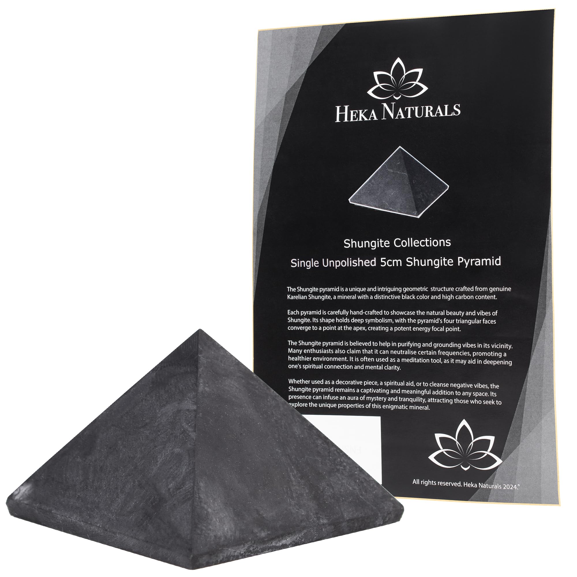 Heka Naturals shungite pyramid on desk purifies surroundings and elevates ambiance.