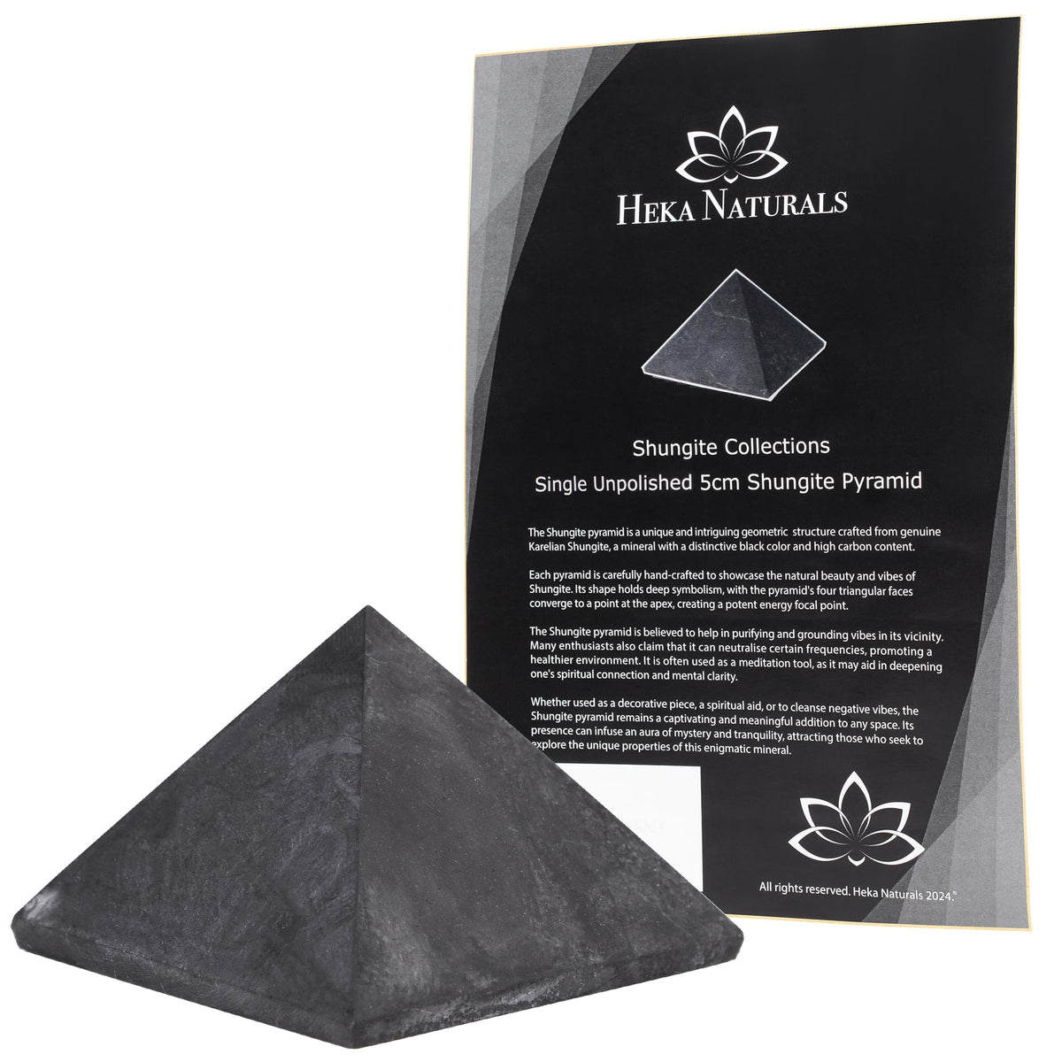 Heka Naturals shungite pyramid on desk purifies surroundings and elevates ambiance.