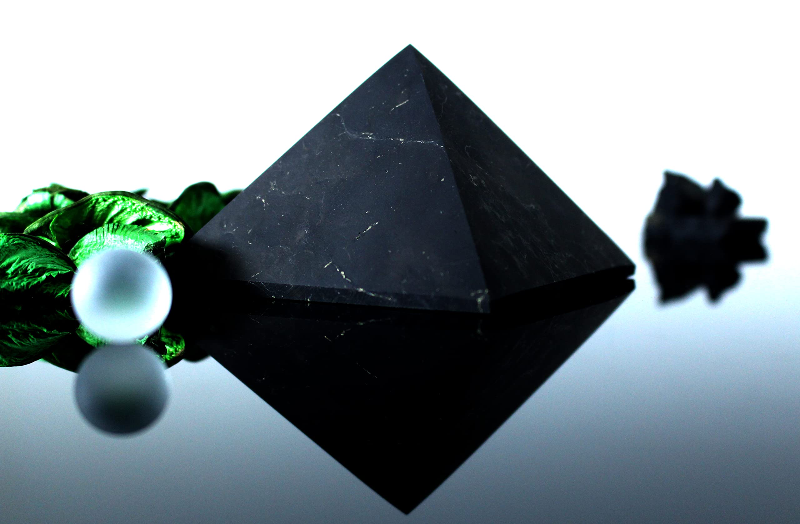Shungite pyramid highlights chakra stones in a clean display