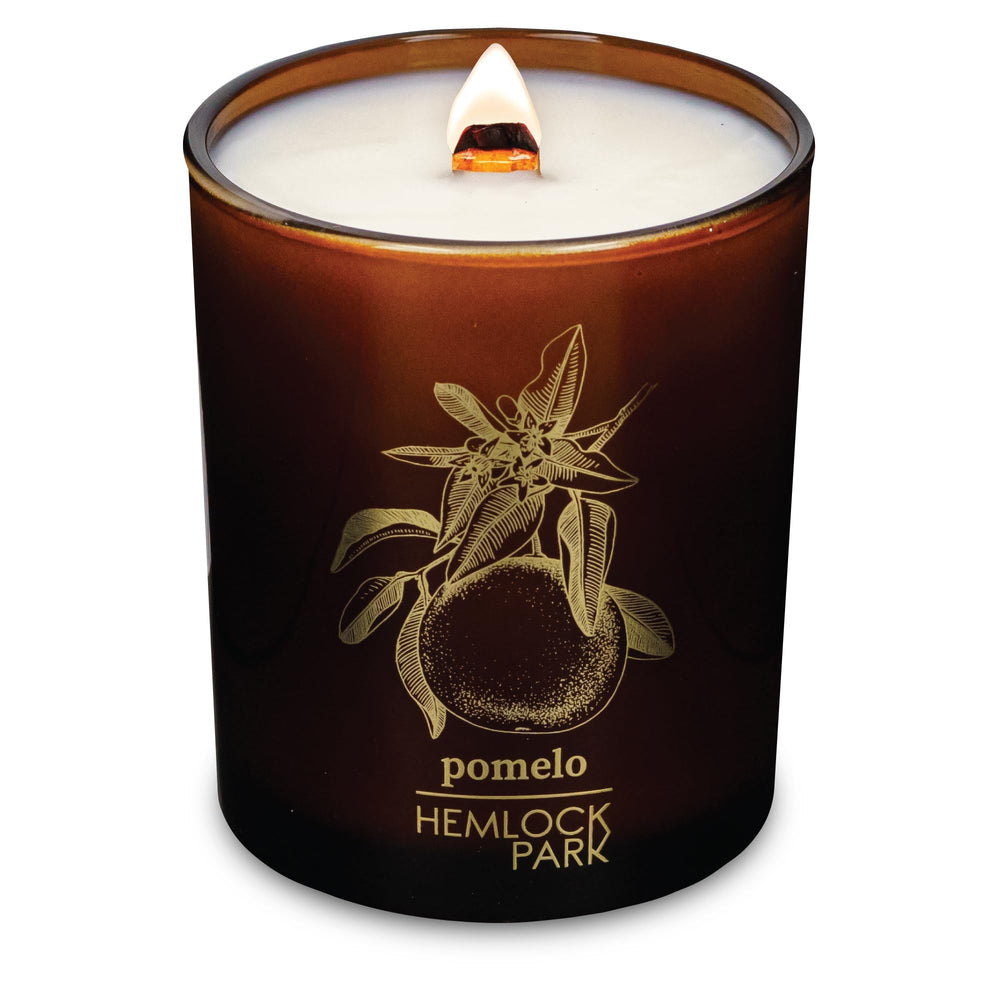 Hemlock Park Amber & Gold wood wick candle with steady flame for cozy ambience.