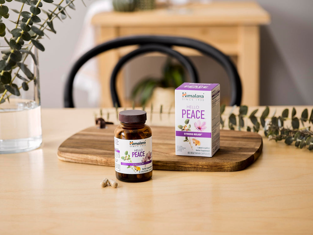 Himalaya Hello Peace bottle with herbs around conveys Ayurvedic relief concept.
