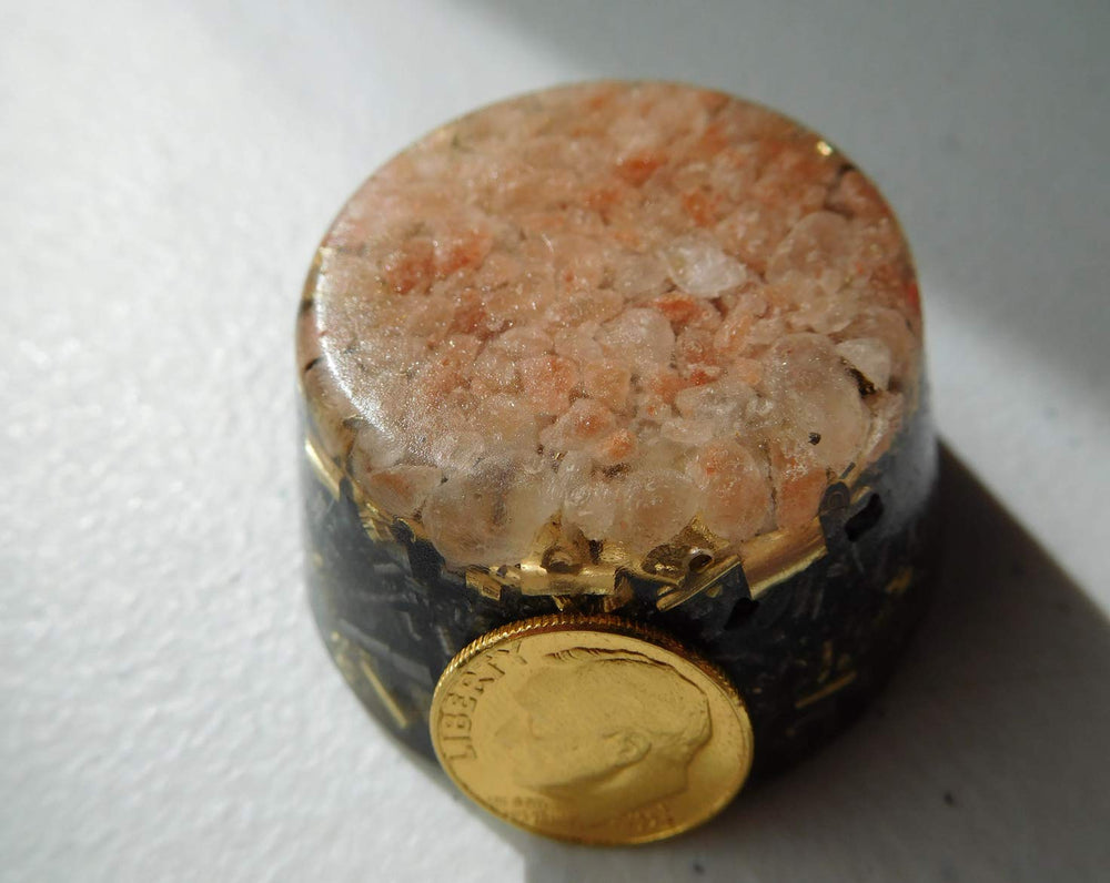 Himalayan Pink Salt Single Crystal Tower Buster Orgone Generator near electronics hints at calmer, focused space