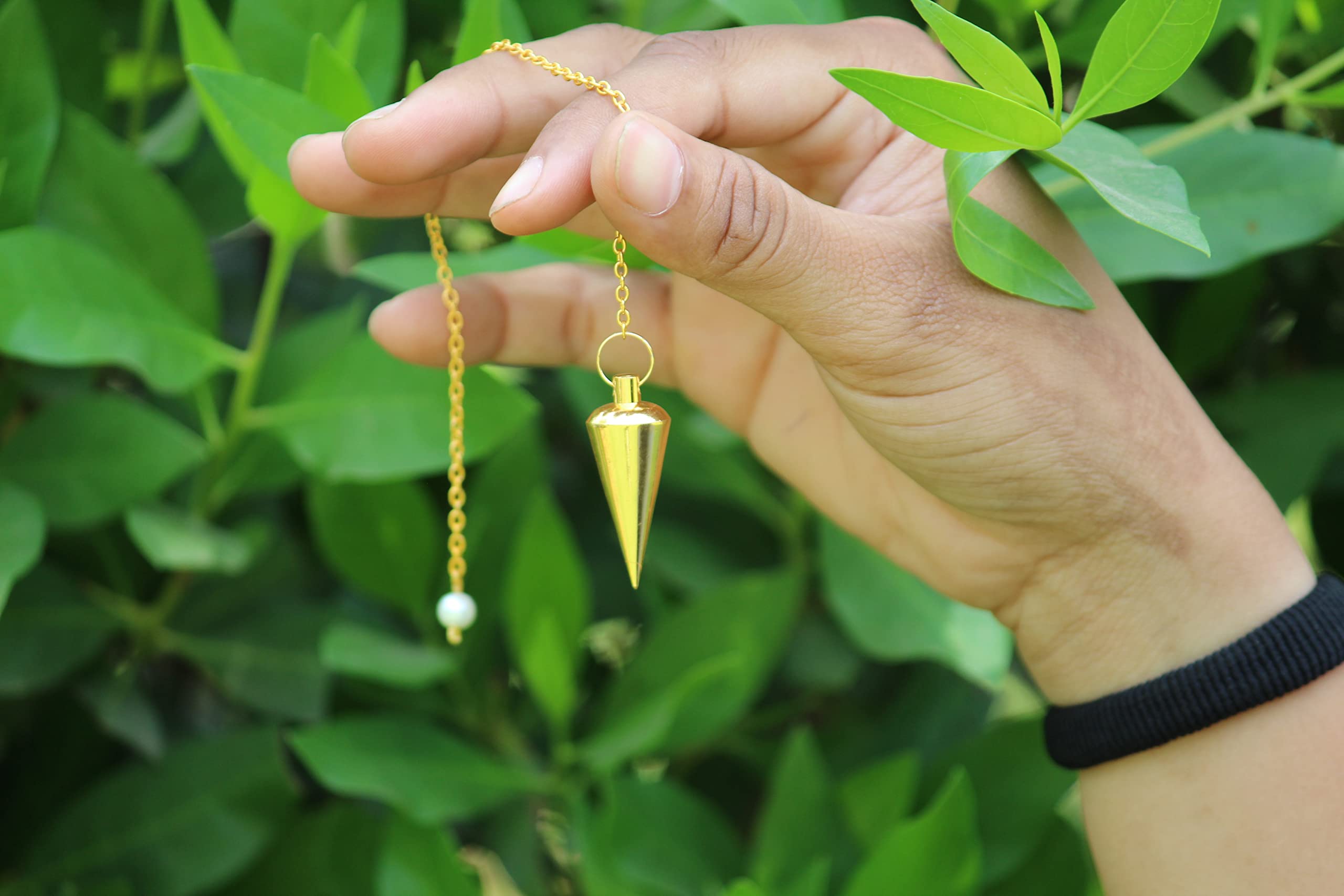 Jet International Gold Cone Chamber Pendulum on display for dowsing setup.