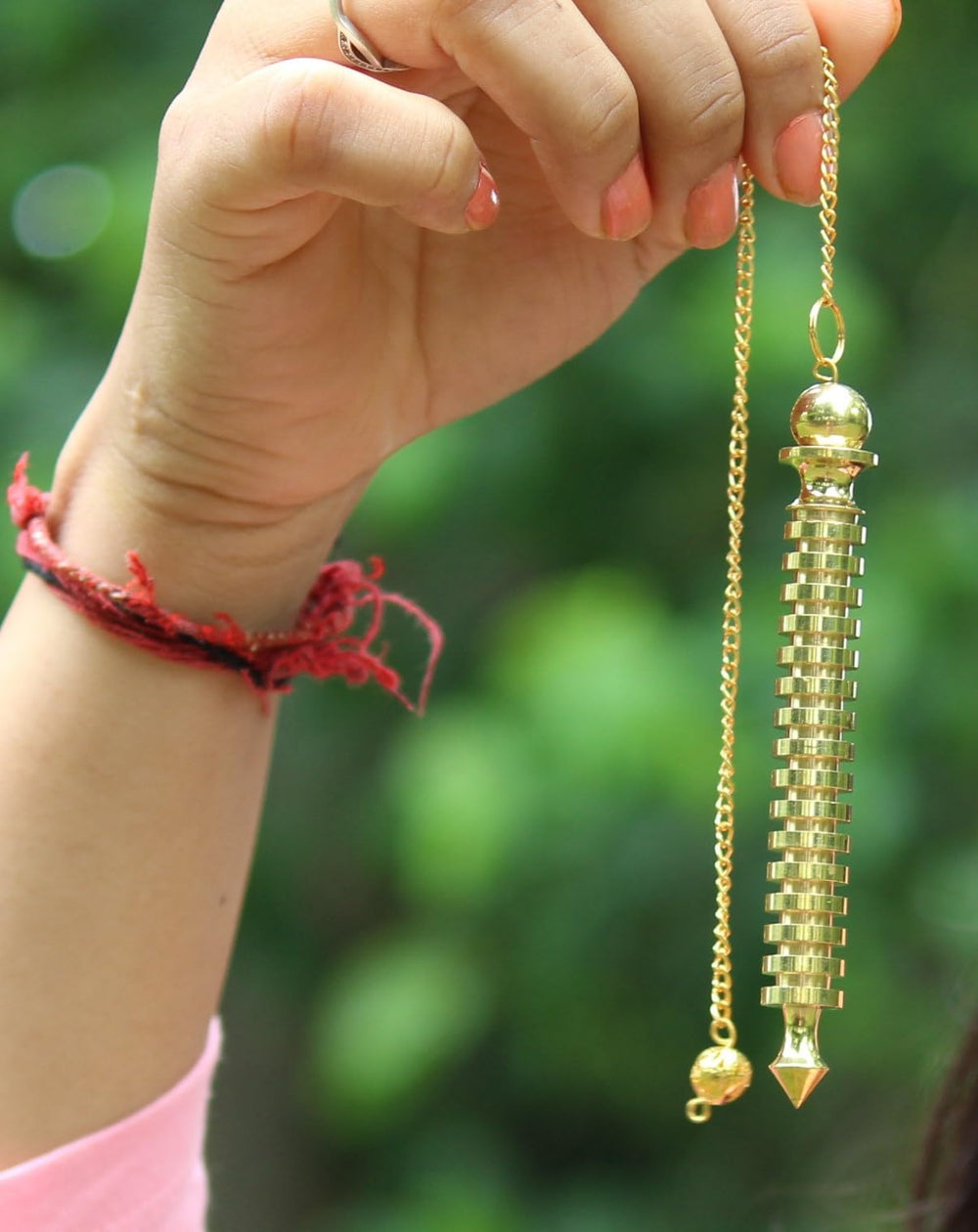 Jet International ISIS brass pendulum in a reflective spiritual practice setup.