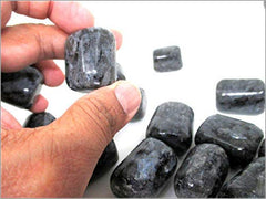 Larvikite tumbled stones from Jet International held in hand for grounding
