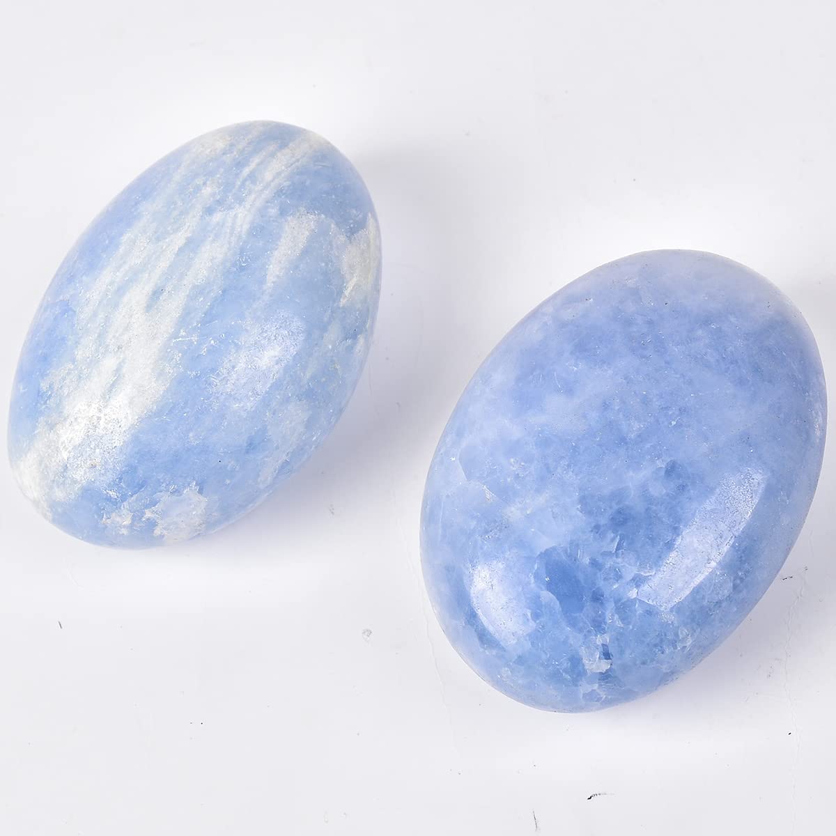JIC Gem blue celestite palm stone resting in palm for meditation.