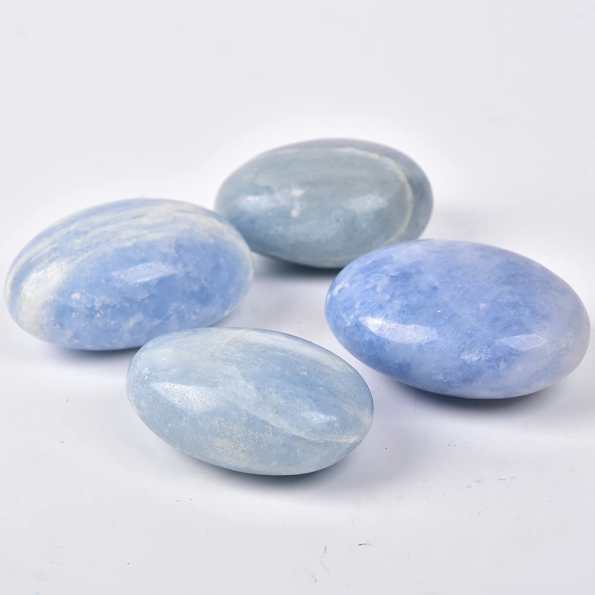 JIC Gem blue celestite palm stone on desk for mindful pauses.