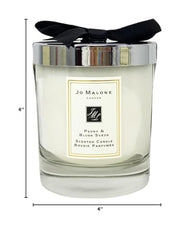 Jo Malone Peony & Blush Suede candle with lit wick for luxury evening scent and soft glow.
