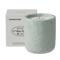 JueOne vanilla and sweet pea scented candle in a cement jar, front view, elegant ambiance.