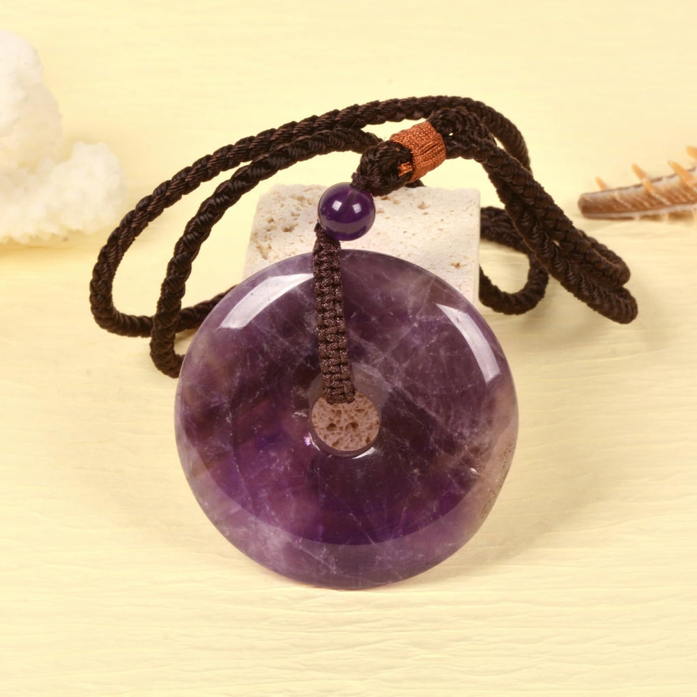 Justinstones Amethyst Peace Donut Pendant on braided cord for versatile wear.