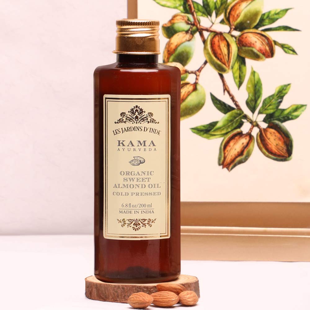 Kama Ayurveda organic almond oil bottle shown with natural ingredients.