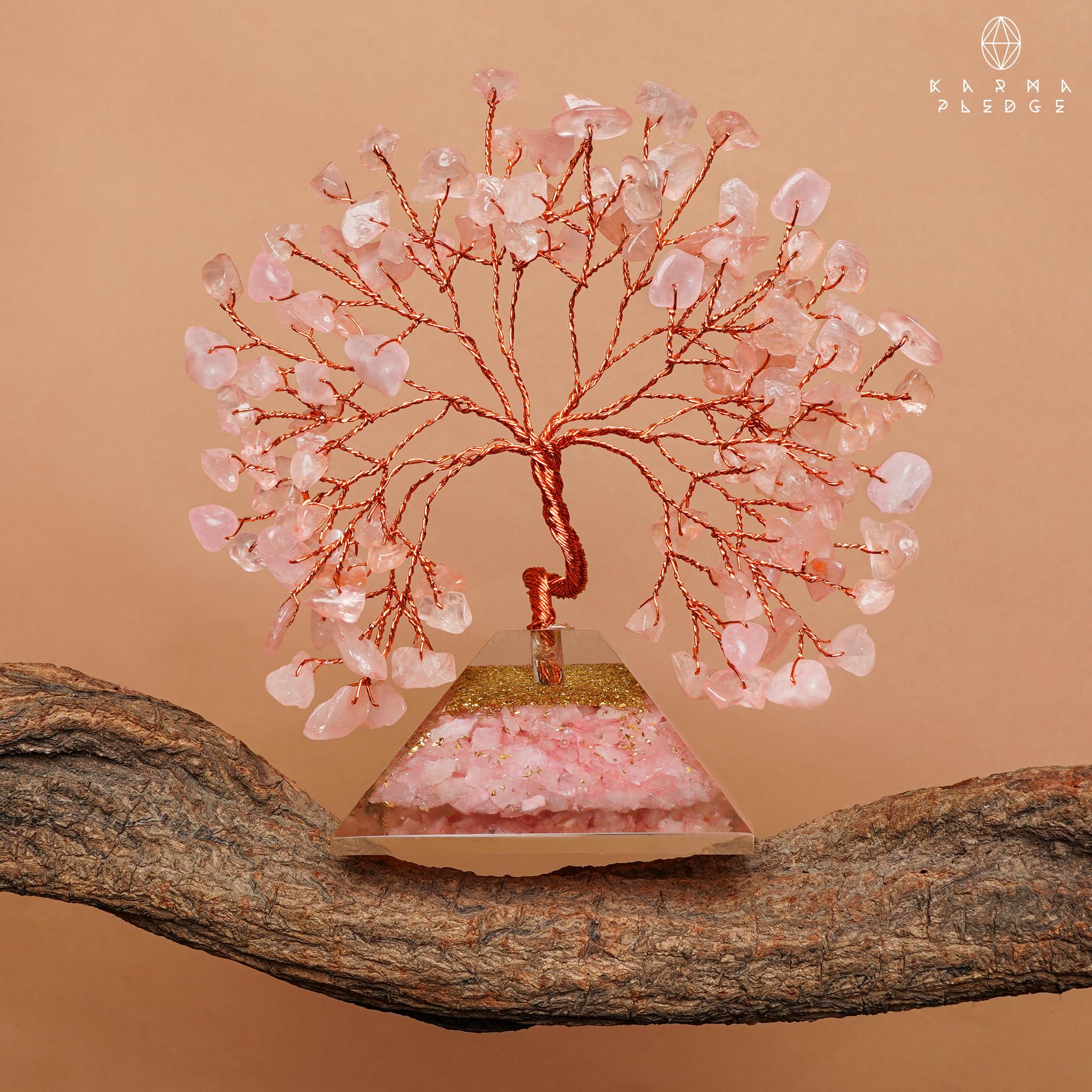 KARMAPLEDGE Rose Quartz Crystal Tree stands beside plants for balanced vibes.