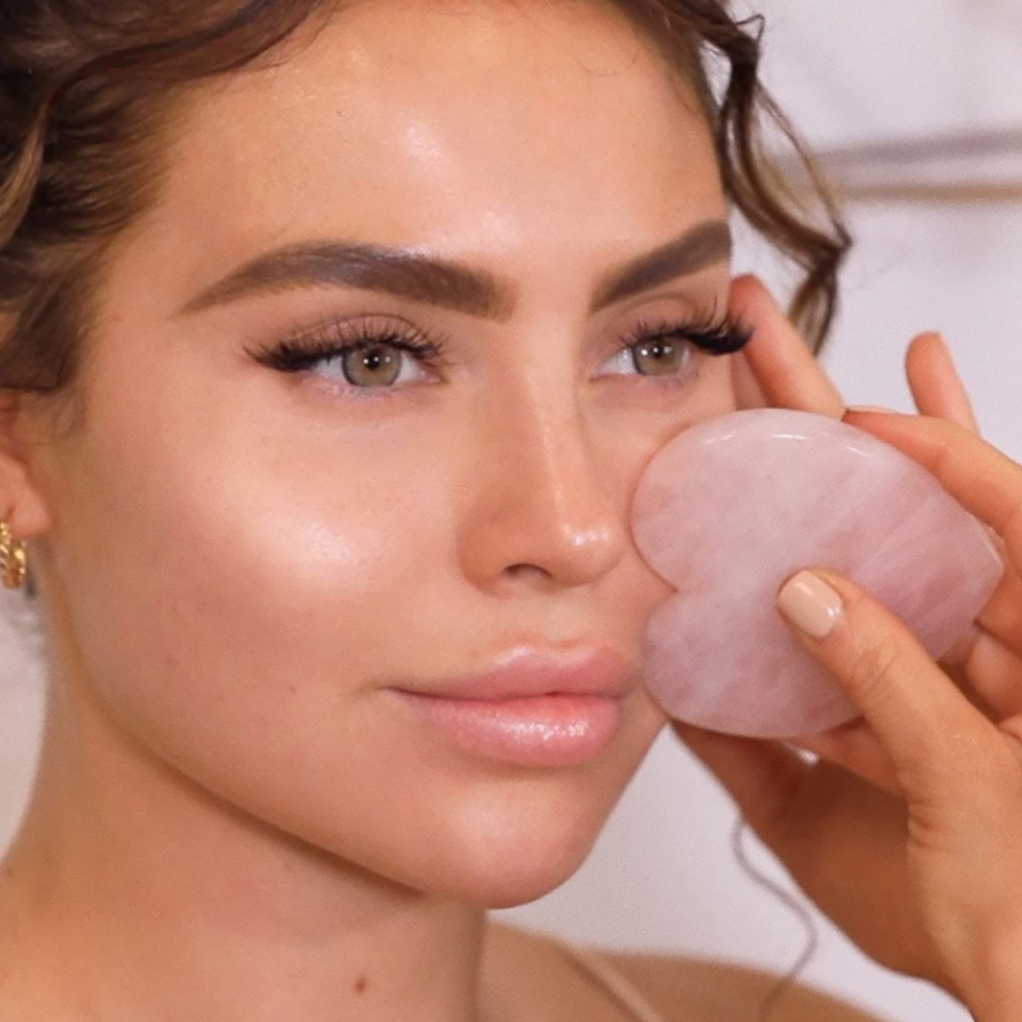 KORA Organics rose quartz heart sculptor with a facial oil for absorption.