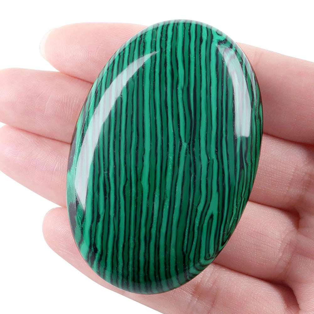 LAIDANLA Malachite palm stone oval held in hand for calm focus and balance.
