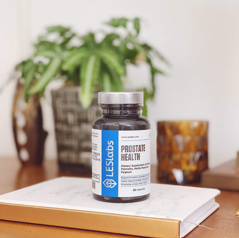 LES Labs Prostate Health product on nightstand next to water glass.