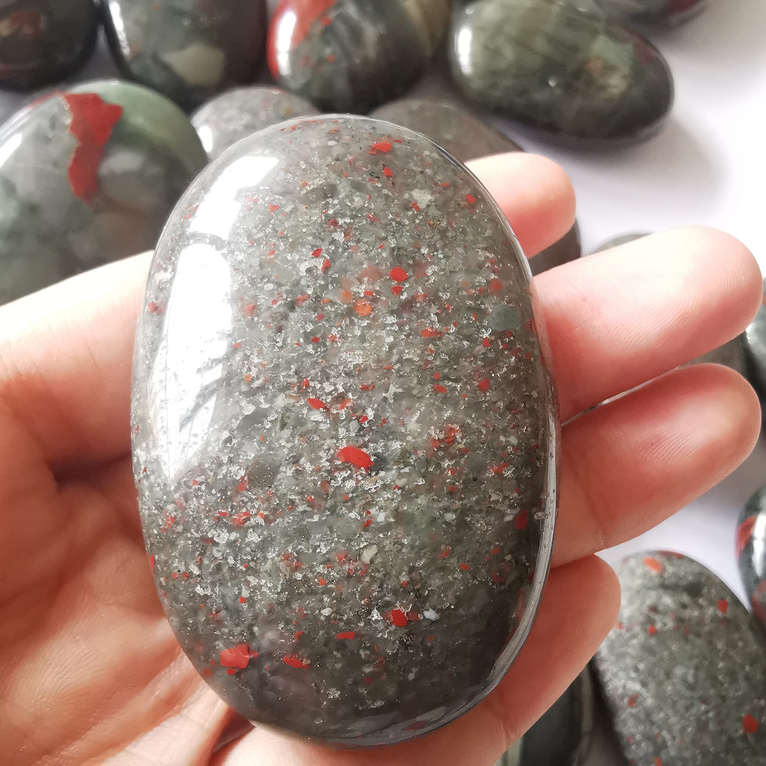 Loveliome bloodstone oval worry stone in hand for easy meditation and calm grip