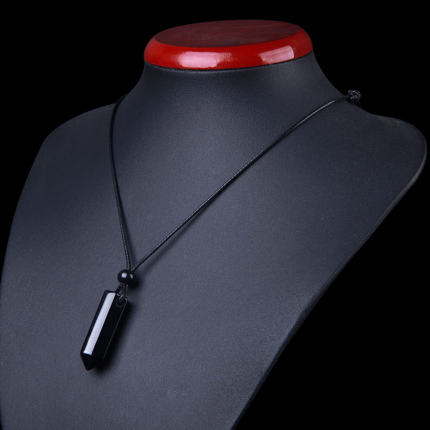 Magic Human Carnelian Necklace hexagonal gemstone detail on smooth black agate surface.