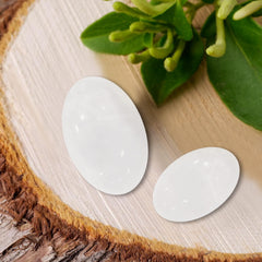 MaziZhang white worry stone thumb detail highlighting smooth cool texture.