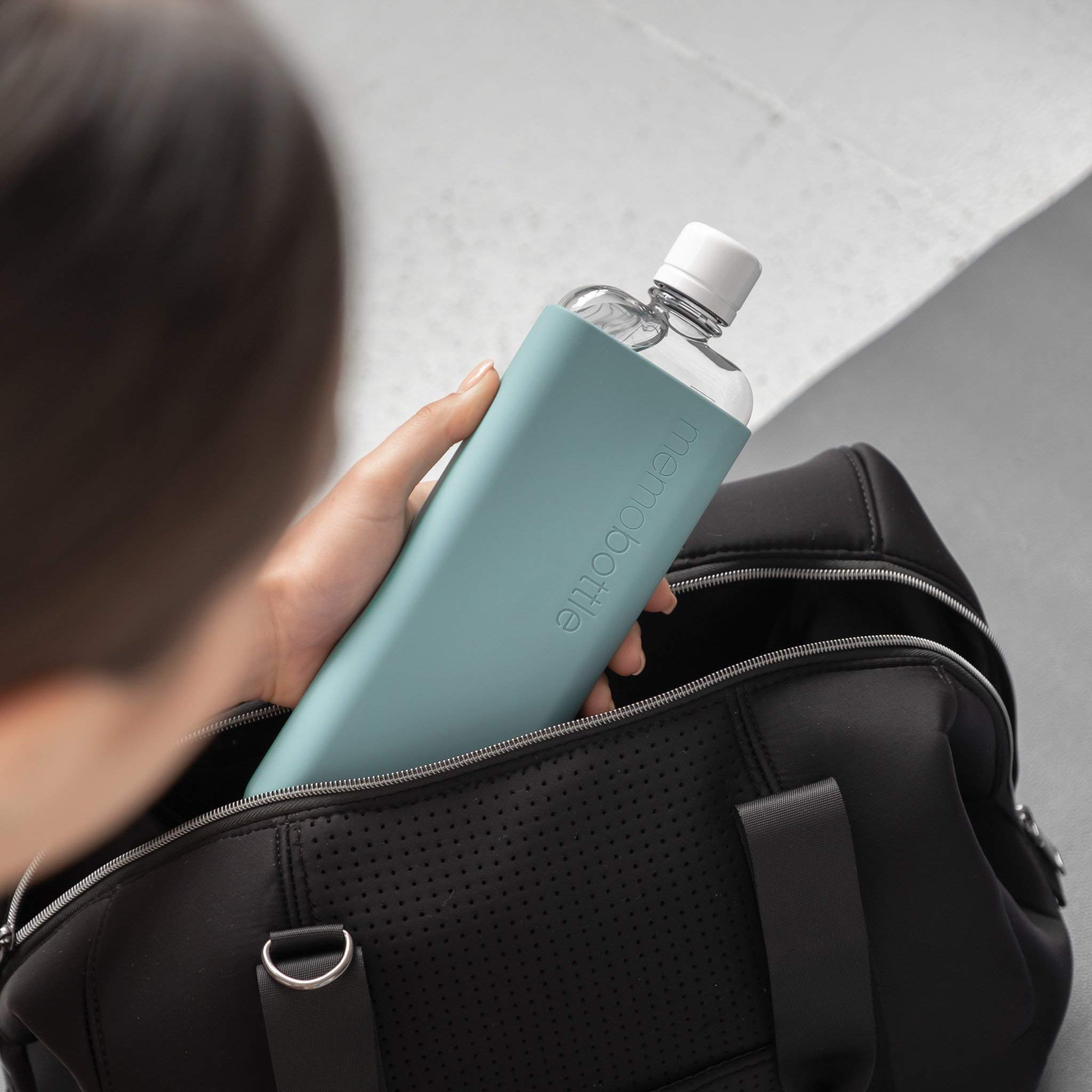 Memobottle SLIM Sea Mist sleeve in hand, emphasizing grip and insulation.