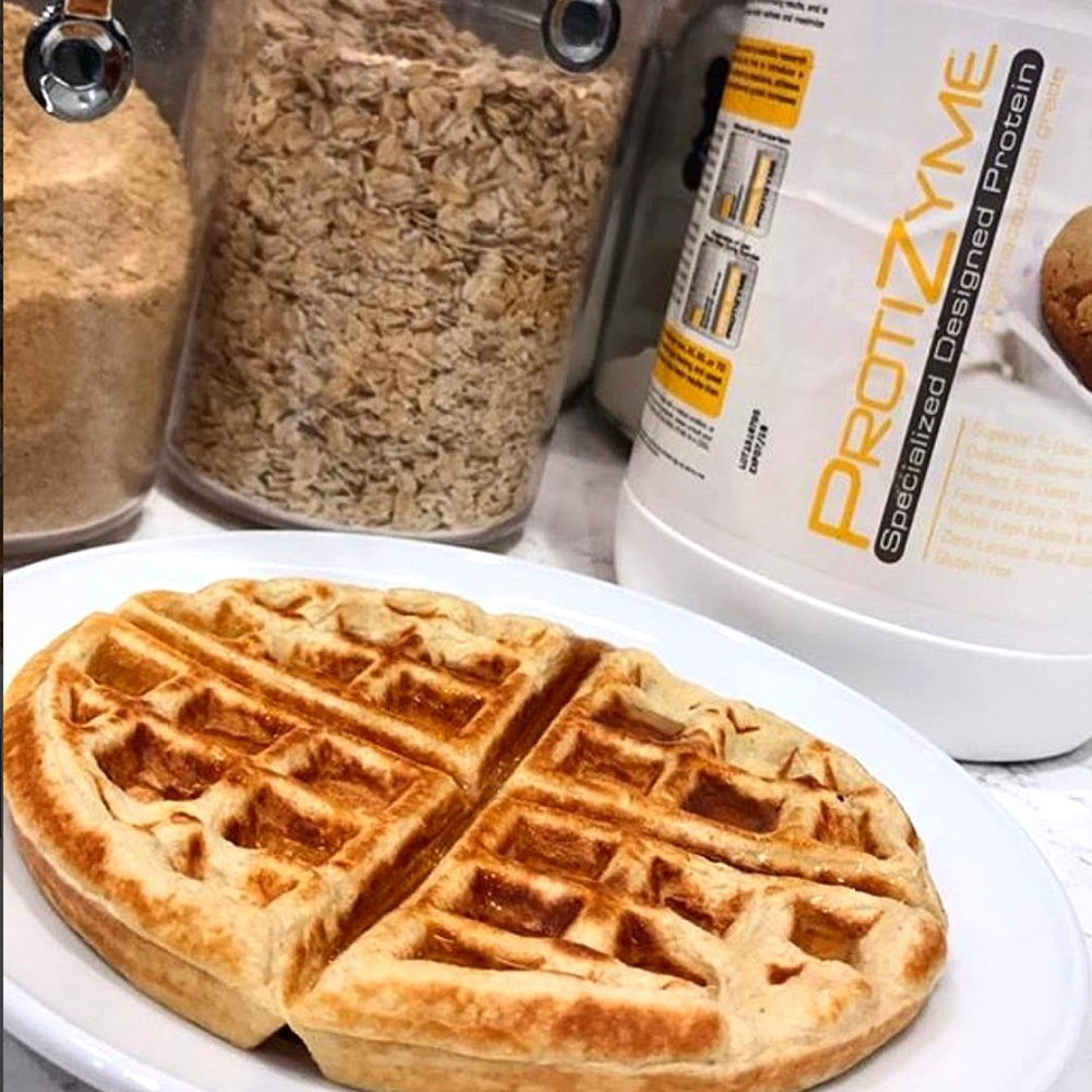 Vanilla cake scoop beside Protizyme packaging emphasizes low sugar