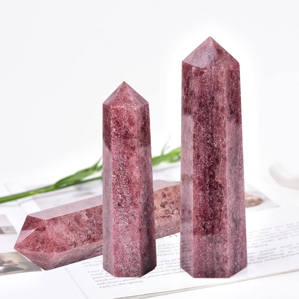 MOGEMT strawberry quartz used in Reiki or chakra work beside a crystal obelisk.